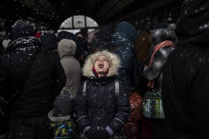 Una niña coge con la boca copos de nieve mientras espera con otros refugiados para subir a un tren con destino a Polonia, en la estación de Lviv en Ucrania occidental. La ONU ha estimado que el conflicto podría producir hasta 4 millones de refugiados.