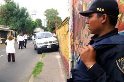 Un policía mexicano corta la calle en la que se encuentra el vehículo del entrenador secuestrado.