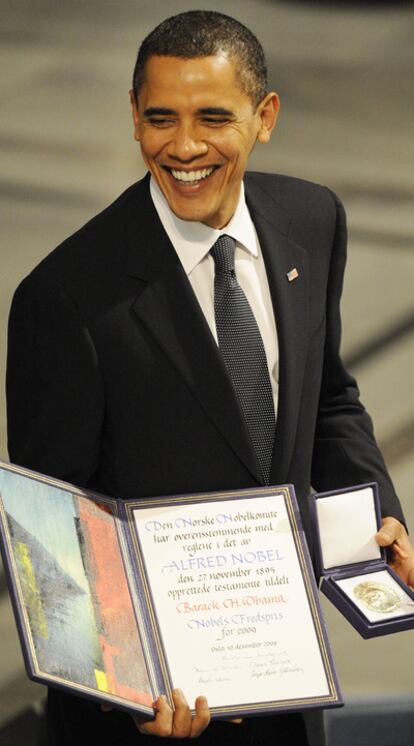 Obama muestra el diploma y la medalla del Nobel de la Paz en Oslo.