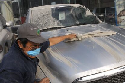 Un hombre limpia la ceniza que cubre un automvil el pasado 8 de mayo en San Pedro Cholula, Estado de Puebla (Mxico).