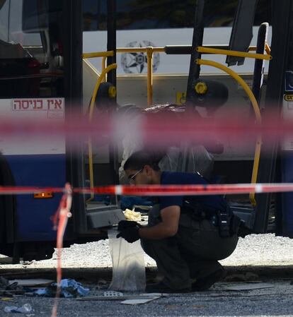 Uno de los forenses israelíes recoge muestras del atentado.