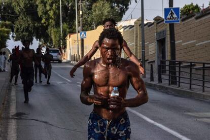 Un hombre echa agua encima tras haber saltado la Valla de Ceuta junto a otros 100 migrantes aproximadamente.