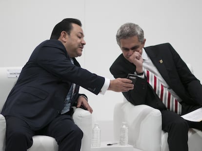 Héctor Serrano, secretario de Gobierno, muestra su teléfono al jefe de Gobierno Miguel Ángel Mancera, en enero de 2014.