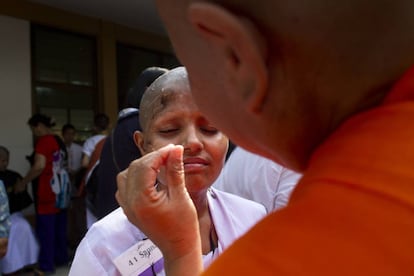 Una mujer laica durante su ceremonia de ordenación como monja novicia budista en el templo Wat Songkdhammakalayani.