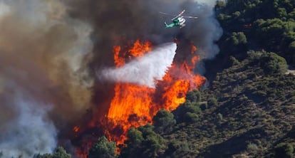 Un helic&oacute;ptero trabaja en el control de un incendio en Cenes (Granada), en agosto.