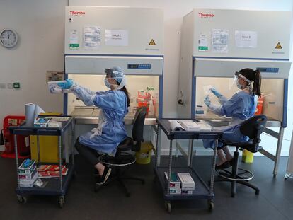 Trabajadores en un laboratorio de Glasgow realizan la fase final del test de coronavirus.