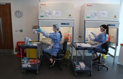 Trabajadores en un laboratorio de Glasgow realizan la fase final del test de coronavirus.