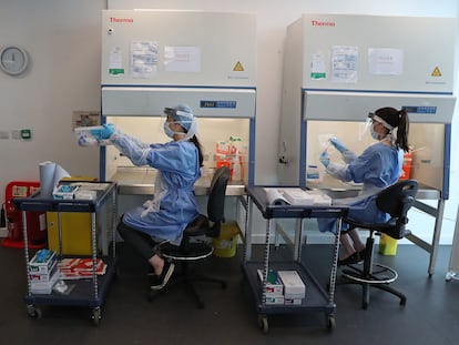 Trabajadores en un laboratorio de Glasgow realizan la fase final del test de coronavirus.
