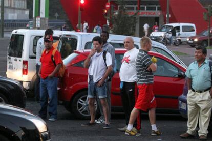 Un grupo de obreros aguarda a las puertas del bar Yakarta para enrolarse en alguna obra.