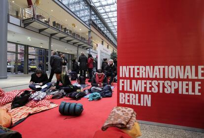 Un grupo de personas acampanadas delante de las taquillas para adquirir entradaspara la 64ª edición del Festival Internacional de Berlín