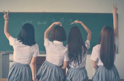 Cuatro niñas juegan en clase.