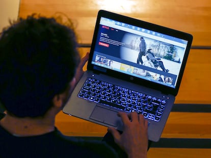 Una persona viendo una película en un ordenador portátil.