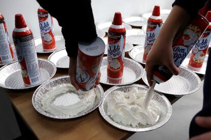 Estudiantes universitarios preparan tartas con nata montada para una fiesta en Hamtramck (Michigan), en 2017.