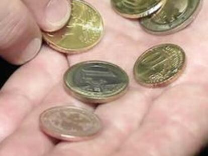 Una persona muestra unas monedas en la mano