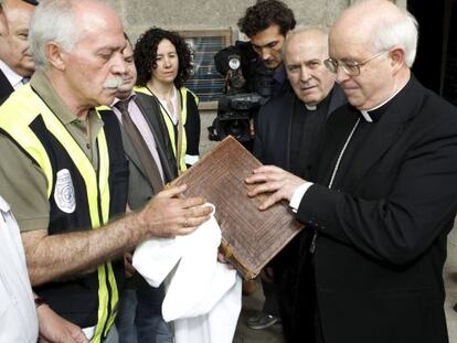 The archbishop of Santiago de Compostela, Julián Barrio, receives the Codex Calixtinus from a police officer on Wednesday.