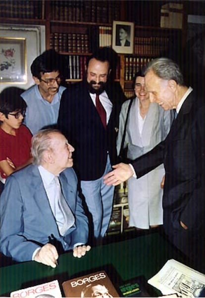 Borges, sentado, conversa con Bioy Casares.
