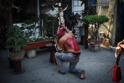 Un penitente con la espalda ensangrentada reza frente a una talla de Cristo, en San Fernando (Filipinas).