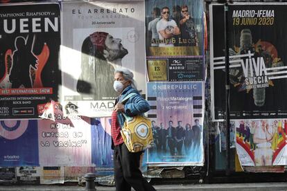 A woman in Madrid passes by posters advertising concerts that have been canceled due to the coronavirus crisis.