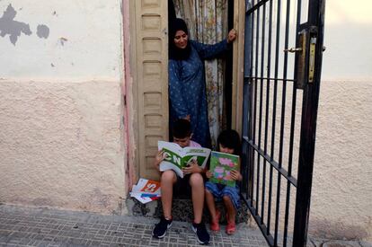 Latifa junto a sus dos hijos en la puerta de su casa en Melilla.