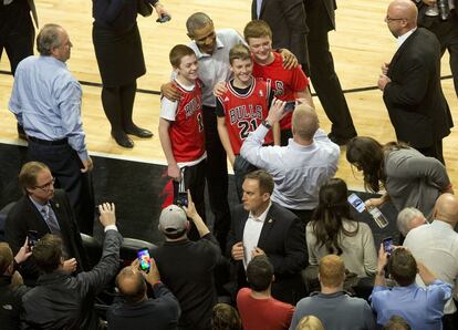 El presidente Obama posa con unos aficionados de los Bulls durante el descanso del partido.