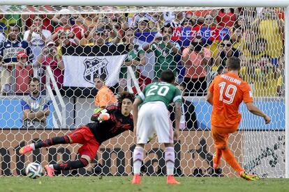 El portero de México Guillermo Ochoa no puede detener el lanzamiento del jugador holandés Klaas-Jan Huntelaar, que anota el segundo gol y el de la victoria de su equipo.