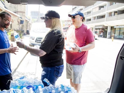 Uma mulher distribui garrafas de água em Toronto, no dia 30 de junho, durante a onda de calor no leste Canadá.