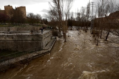 Un hombre toma imágenes del caudal del río Adaja en Ávila, este viernes.