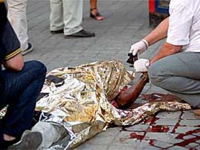 Un policía toma las huellas dactilares al cadáver del nigeriano muerto ayer en la plaza de la República Argentina.