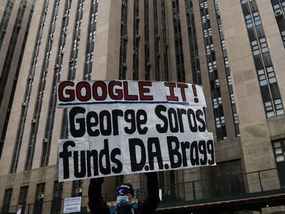 A protestor holds a placard against billionaire investor George Soros outside Manhattan Criminal Court