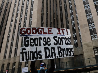 A protestor holds a placard against billionaire investor George Soros outside Manhattan Criminal Court