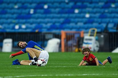 Gerard Piqu&eacute; juega con su hijo Milan en el c&eacute;sped del Bernab&eacute;u despu&eacute;s del partido contra Italia.  