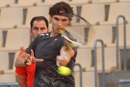 El tenista español Rafa Nadal se prepara en la pista del estadio de la Cartuja para la final de la copa Davis ante Argentina