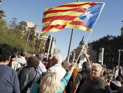 Una mujer sostiene una estelada, en una pegada de carteles en Barcelona. 