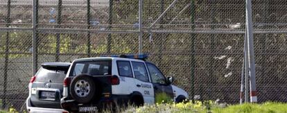 Varios coches de la Guardia Civil aparcados junto a la valla de Melilla.