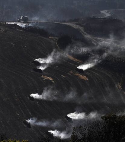 Pacas de paja aún humeantes por el incendio declarado ayer entre las localidades de Tafalla y Pueyo, en Navarra, que se encuentra ya estabilizado después de afectar a cerca de 3.000 hectáreas, el de mayor superficie en la Comunidad foral desde 1989.