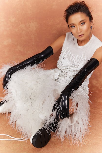 Ashley Park con vestido de PRABAL GURUNG, notas de STUART WEITZMAN, pendientes de OUTHOUSE, y 'earcuffs' y guantes de BVLGARI.