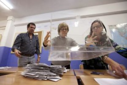 Miembros de una mesa electoral en un colegio de Vitoria vacían la urna.
