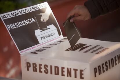 Un hombre deposita su voto en una urna electoral.