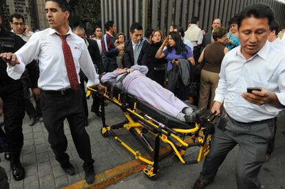Una persona herida es transportada en camilla en las inmediaciones de la sede de Pemex.