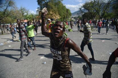 Una manifestante realiza un gesto amenazante durante los enfrentamientos frente al Palacio Nacional de Puerto Príoncipe (Haití), el 13 de febrero. Las manifestaciones, que han aumentado la inseguridad en esta nación caribeña y provocado un clima de caos e incertidumbre, se producen en medio de una severa crisis económica, que se agravó este año por una fuerte depreciación del gourde, la moneda oficial, y por la crisis de electricidad derivada de la escasez de gasolina.