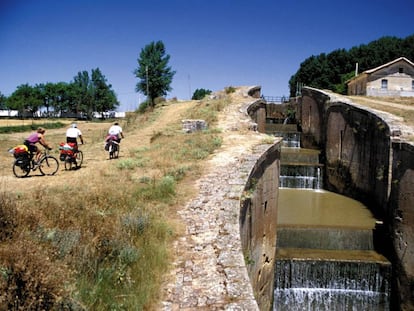 Ciclistas en el Canal de Castilla, junto a la esclusa cuádruple, en Frómista, Palencia.