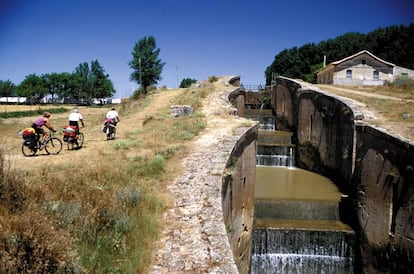 Ciclistas en el Canal de Castilla, junto a la esclusa cuádruple, en Frómista, Palencia.