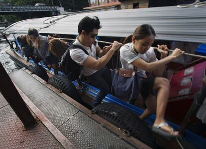 Uns passatgers baixen d'una embarcaci a motor al moll del canal Saen Saeb a Bangkok (Tailndia).