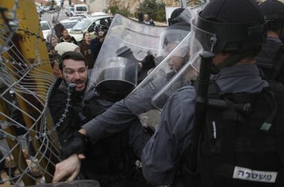 Policías y colonos durante los enfrentamientos del jueves en el asentamiento judío de Dolev, en Cisjordania.