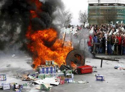 Un carro y varios cartones de leche arden durante la protesta de los ganaderos ante Leche Río