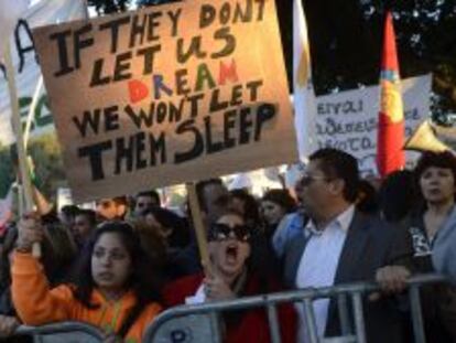 Una manifestante protesta en Chipre y muestra una pancarta en la que se puede leer &quot;si ellos no nos dejan so&ntilde;ar, nosotros no les dejaremos dormir&quot;, 