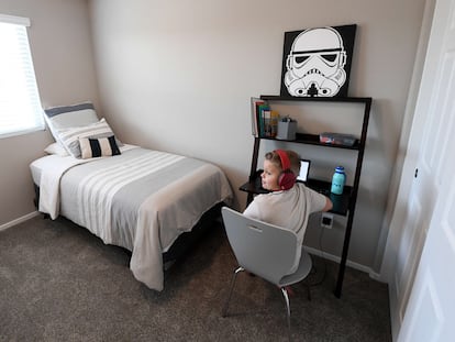 Un niño utiliza el ordenador en su cuarto, en el que hay un cuadro de 'Star Wars'.