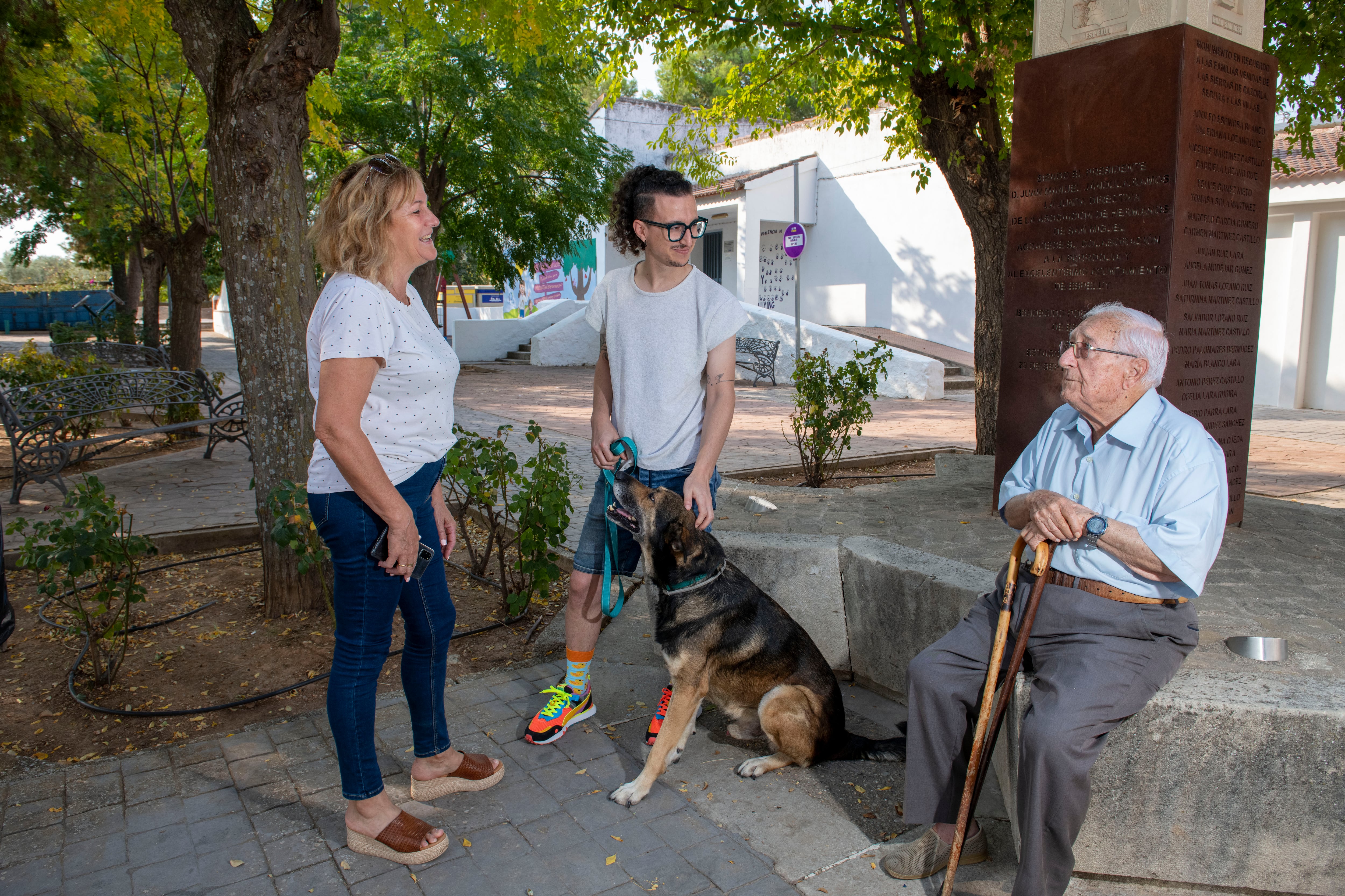 Unos vecinos de la localidad de Espeluy hablan en la plaza del pueblo sobre la comodidad de no tener que ir a otro pueblo a sacar dinero en un cajero. 