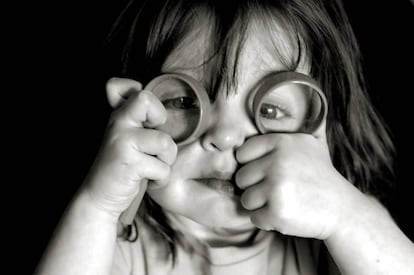Niña juega con unas lentes.