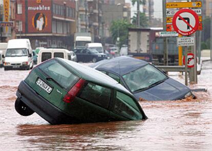 Vehículos arrastrados por la tromba de agua en una de las calles de Nules.